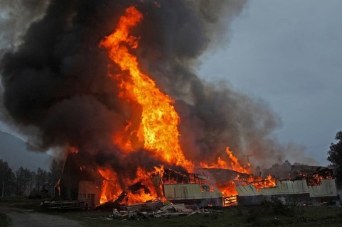 Flames and smoke rise from burning farm building