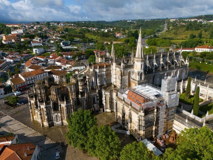 Gothic cathedral with cityscape in the background, some areas under construction, aerial view,