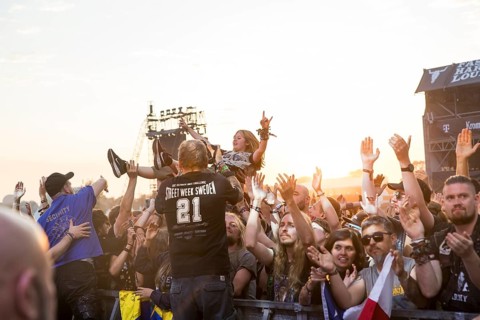 Crowdsurfers in front of the evening sun at the Wacken Open Air in Wacken. The traditional metal