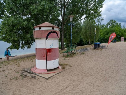 Old round red-white-ringed changing room from GDR times in the shape of a lighthouse on the shore