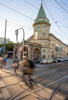 Cyclists crossing the traffic light at red at Stiglmaierplatz, motion blur, Löwenbräukeller of the