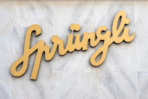 Company logo, advertising sign of the chocolate manufacturer Confiserie Sprüngli AG on a house