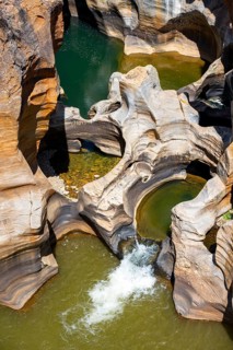 Eroded rock formations, canyon with steep orange-coloured rock cliffs with the Blyde River,