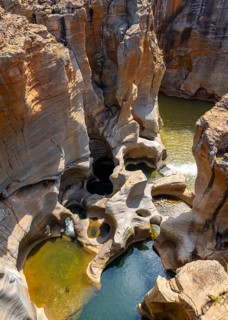 Eroded rock formations, canyon with steep orange-coloured rock cliffs with the Blyde River,