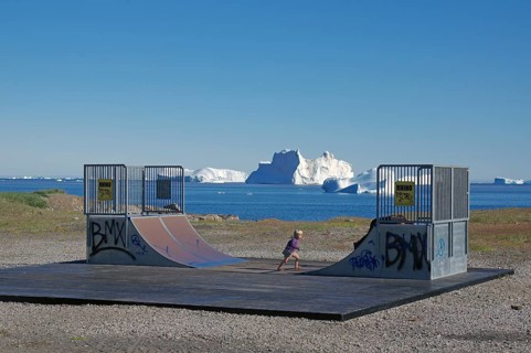 Halfpipe near a beach with icebergs in the sea and a BMX-riding kid, blue sky, end of the world,