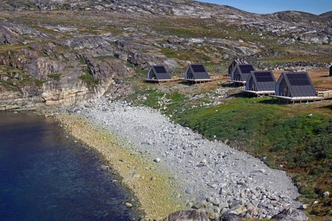 Cabins along a rocky coast with sea views, surrounded by nature and hills, tourism, accommodation,