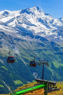 Gondolas of the cable car from Zinal to Corne de Sorebois, behind the snow-covered Weisshorn, Val