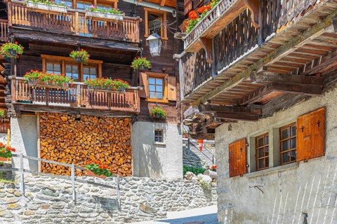 Old wooden houses with flower boxes in front of windows and balconies in the historic village