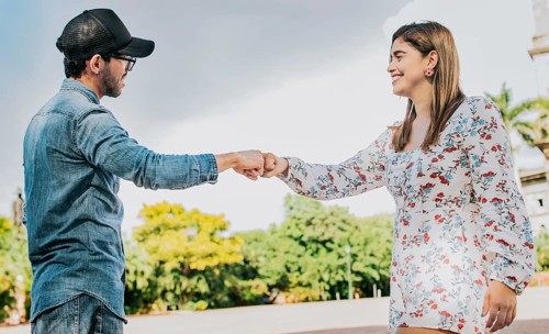 Man and girl shaking hands on the street. Two young smiling teenagers shaking hands in the street