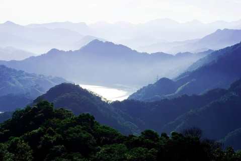 A misty mountain range with layered hills and valleys bathed in tranquil morning light, Shimen