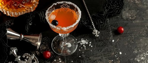Vintage-style cocktail with a sugar rim and cherries, set against a dark, elegant background, AI