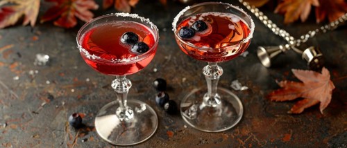 Festive cocktail glasses with blueberries and sugar rims, surrounded by autumn leaves, AI generated