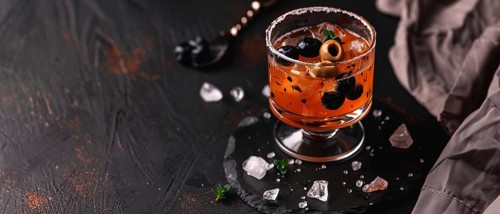 Stylish cocktail with olives and blueberries, presented in an elegant glass on a dark textured