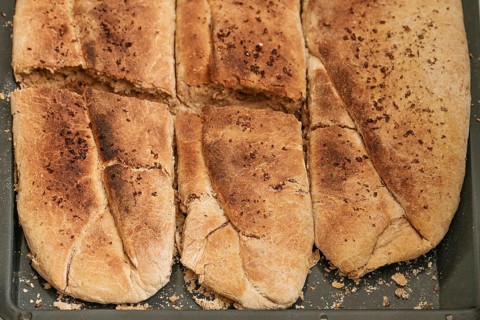 Freshly baked bread from wheat and whole meal flour with yeast on a baking tray, high angel view