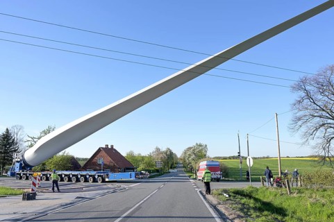 Heavy duty transport of a windmill blade lifted up to avoid obstacles such as a power lines on a