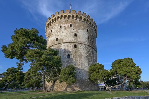 White Tower of Thessaloniki, Greece, famous landmark between pine trees and travel destination for