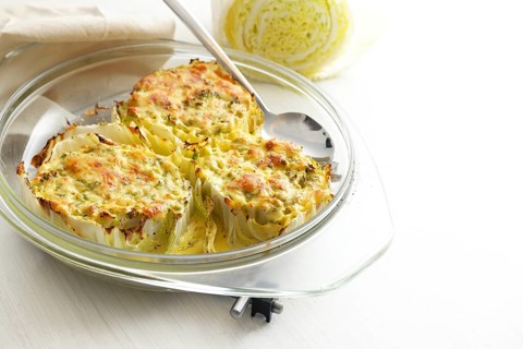 Chinese or napa cabbage gratinated in a glass casserole on a light gray table, healthy cooking,