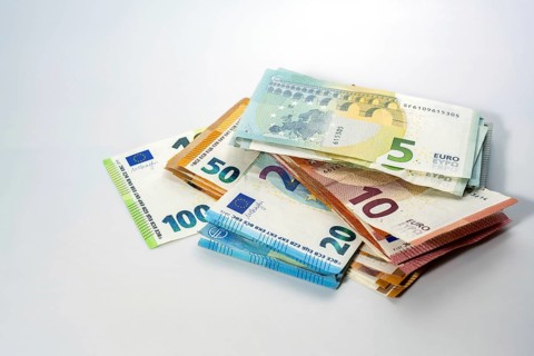 Stack of different euro banknotes on a light gray background, concept for business, finance,