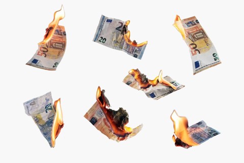 Burning money, collection of twenty and fifty euro banknotes with flames isolated on a white