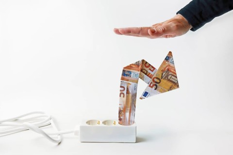Power strip with rising arrow made of euro banknotes, hand from above is limiting price growth
