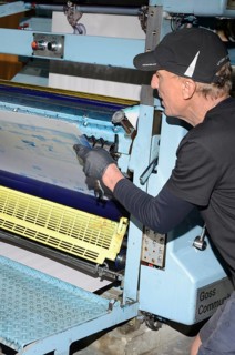 GREYMOUTH, NEW ZEALAND, MAY 22, 2015: An unidentified printer removes the plates after printing a