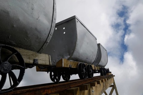 A coal mining memorial at Dobson in New Zealand features vintage coal wagons from an underground
