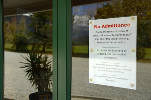 Signage shows that an essential food processing business has restricted access during the Covid 19