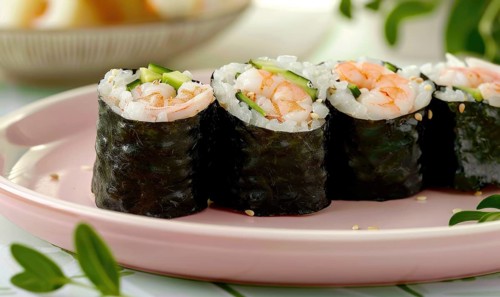 Shrimp and avocado rolls with seaweed on a pastel pink plate AI generated