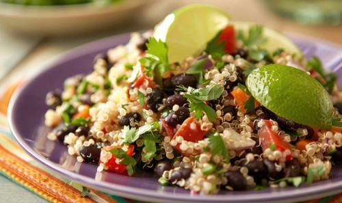 Quinoa and black bean salad with lime on a pastel purple plate AI generated