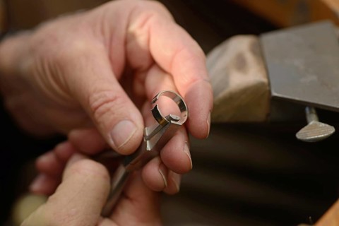 A goldsmith resizes a gold ring