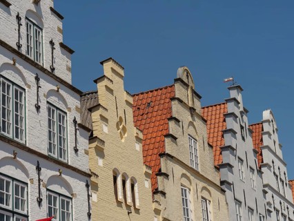 Historic half-timbered houses with characteristic gables and brick facades under a blue sky,