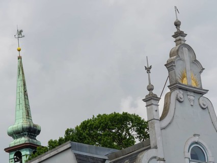 Close-up of a church with ornate spires and a weather vane in front of a grey sky, Kappeln,