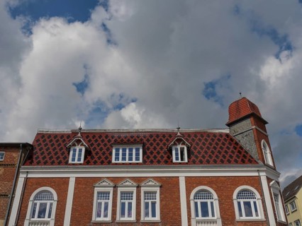 Historic building with red roof tiles under a cloudy sky, Kappeln, SChleswig-Holstein, Germany,