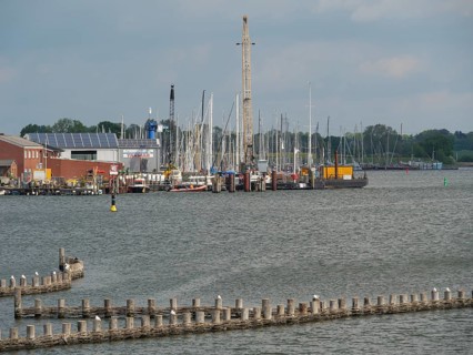 Harbour with many sailing boats and buildings along the shore under a cloudy sky, Kappeln,