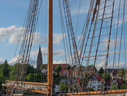 Detail of a sailing mast with a view of a church and houses in the background, Eckernförde,