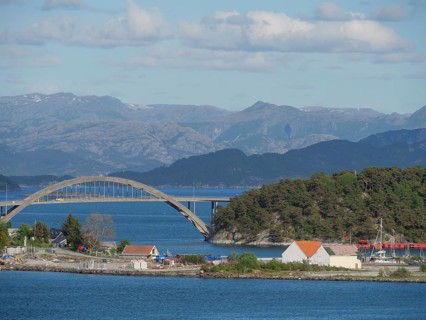 Bridge over the sea, surrounded by mountains, sky and clouds and houses on the shore, Stavanger,