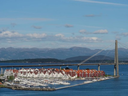 Marina with bridge spanning the sea and houses with red roofs, Stavanger, Norway, Europe