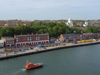 A coastal town with buildings and a boat in the harbour, Newcastle, England, Great Britain