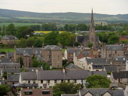 A village with a church and houses surrounded by green countryside and hills, inverness, Scotland,