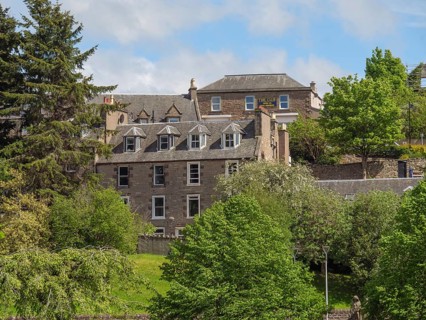 Historic buildings surrounded by green trees and vegetation on a sunny day in spring, inverness,