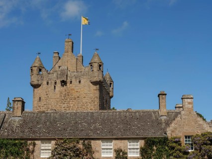 Historic stone castle with towers and a flag under a clear blue sky, inverness, Scotland, United