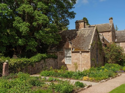 Small stone house in garden with trees and sunny weather, inverness, Scotland, United Kingdom,