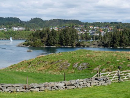Lake surrounded by meadows and a village with houses, mountains in the background, relaxed