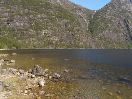 Lake with clear water, surrounded by high mountains and dense vegetation, quiet and peaceful