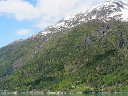 Snow-capped mountains and green hills under a clear sky in calm weather, Eidfjörd, Norway, Europe