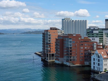 Modern residential building on the waterfront with blue sky and clouds in the background,