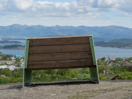 A wooden bench with a view of a picturesque mountain landscape under a cloudy sky, Stavanger,