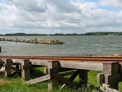 View of a wooden jetty on the lake under a partly cloudy sky, Maasholm, Schleswig-Holstein,