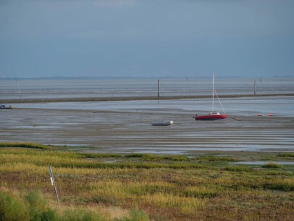 Wide mudflats with boats in the shallow water and a calm, peaceful feeling, juist, east frisia,