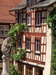 Historic half-timbered house with a bear figure and ivy climbing the façade, Meersburg, Germany,